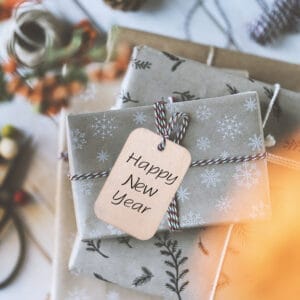 Happy New Year gift tag on rustic wood pieces for crafts, perfect for holiday decorations.