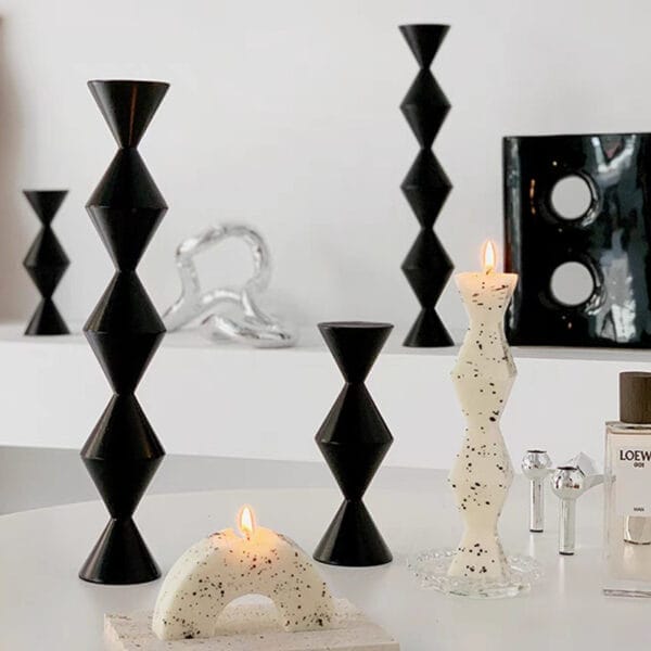 Geometric black candle holders and speckled pillar candles. Eco-friendly Nordic style.