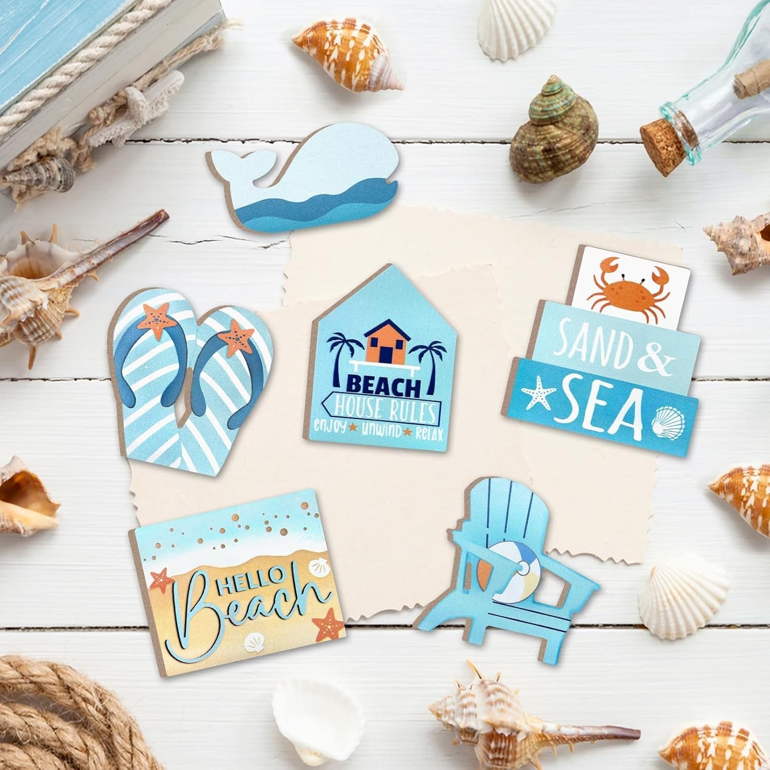 Assorted wooden beach signs with seashells on a white background