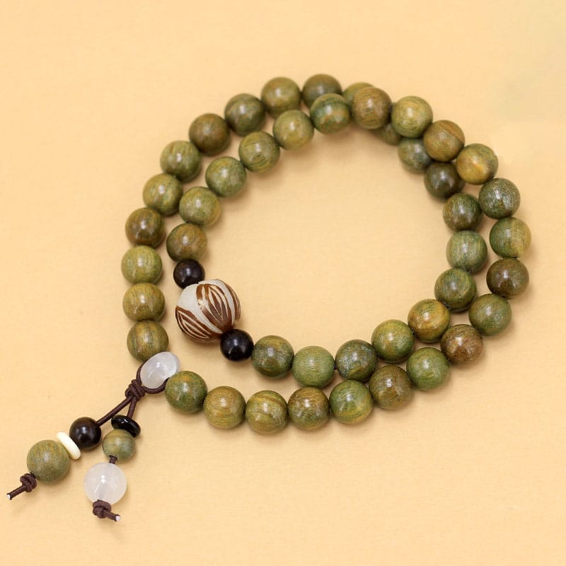 Green wooden bead bracelets with decorative accents. Wholesale beaded bracelets available.