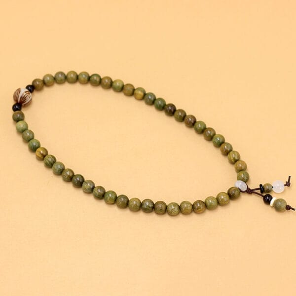 Green wooden bead bracelet with decorative accents. Wholesale decorative beaded bracelets available.