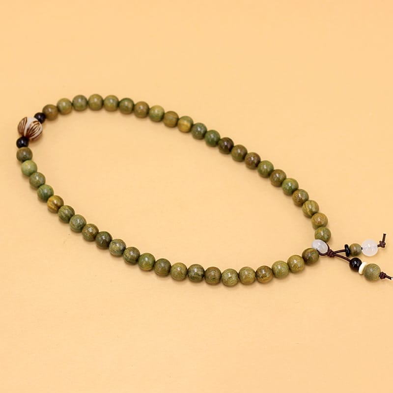 Green wooden bead bracelet with decorative accents. Wholesale decorative beaded bracelets available.