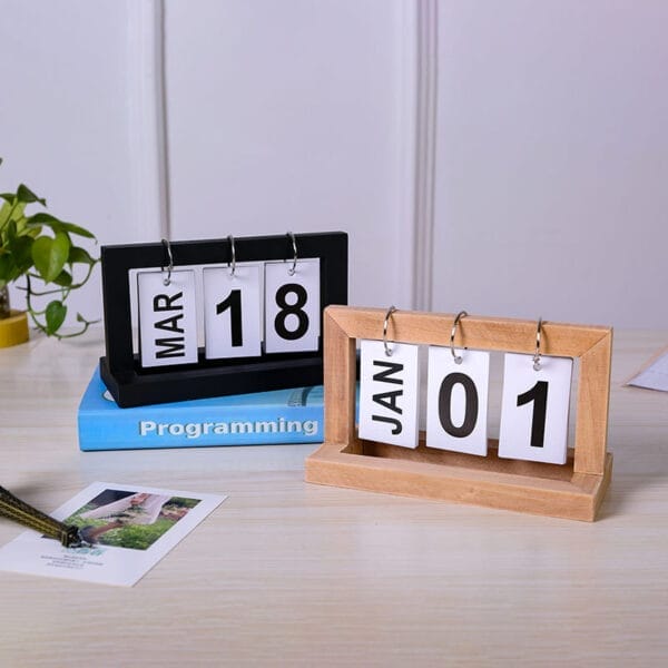 Two wooden perpetual calendars, one black and one light wood, showing March 18th and January 1st. Eco-friendly flip calendars.