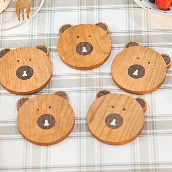 Set of five cute bear-shaped wooden coasters. Perfect for adding charm to your home decor.