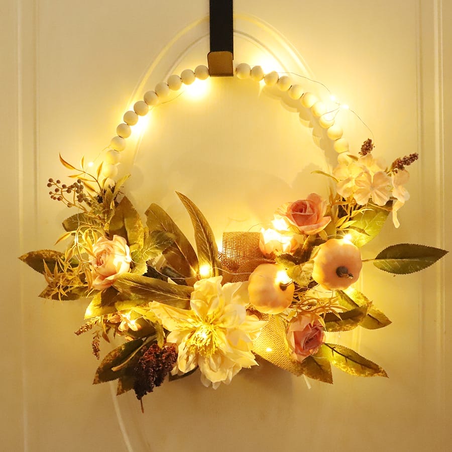 Illuminated autumn floral wreath with wooden beads, perfect for wholesale.