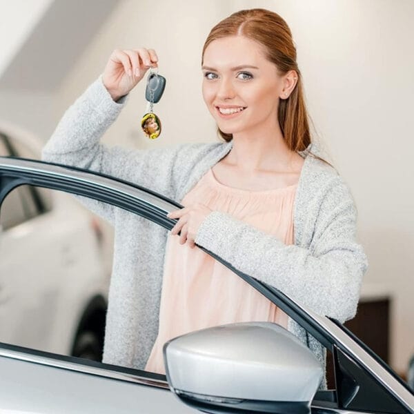 Woman holding car keys with custom photo keychain.