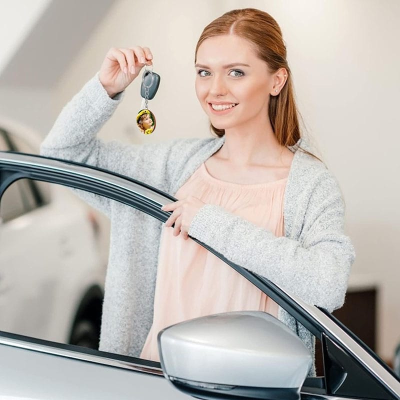 Woman holding car keys with custom photo keychain.