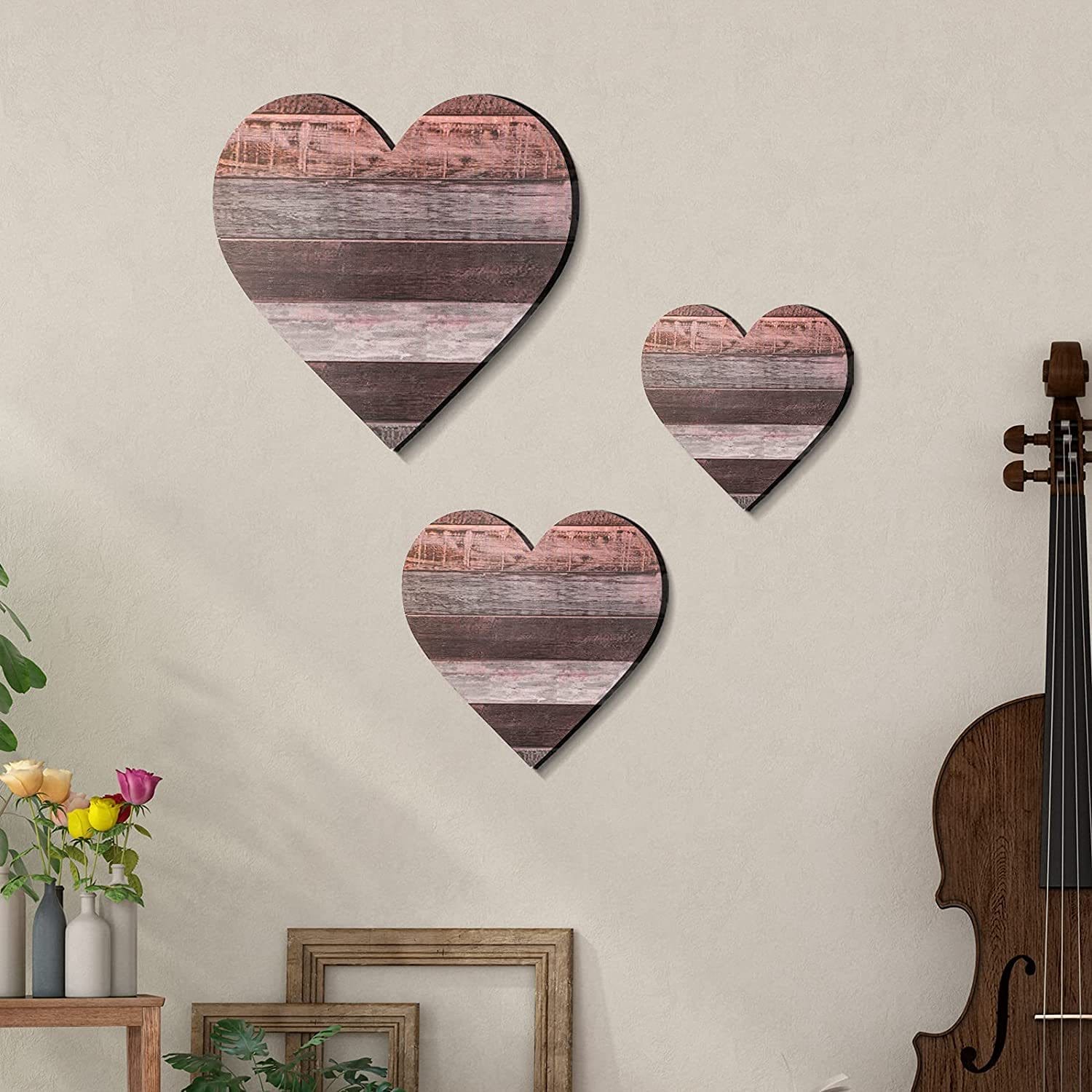 Three rustic wooden heart wall decorations in varying sizes. Heart-shaped bedroom wall decor.