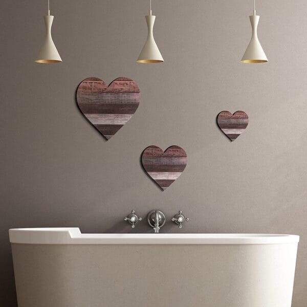 Three rustic wooden heart wall decor pieces in a bathroom. Heart-shaped bedroom wall art.
