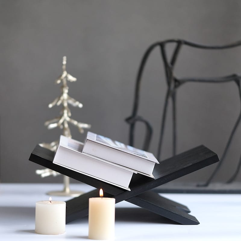 Black wooden magazine holder and reading tray, displaying books. Stylish wood display rack.