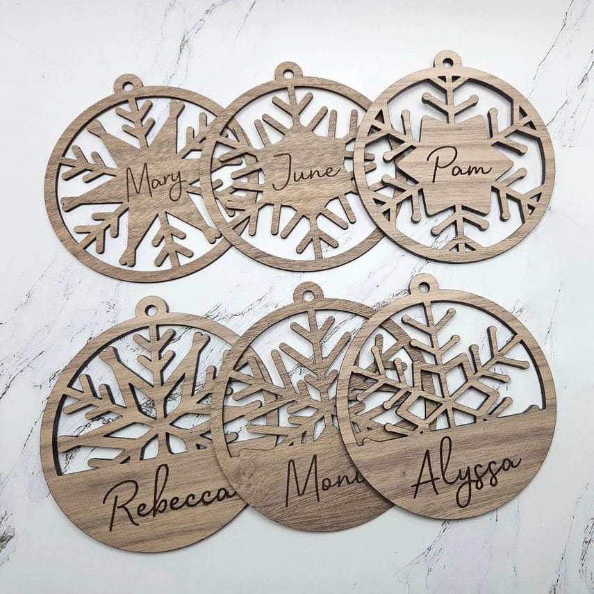 Six personalized wooden snowflake ornaments with names Mary, June, Pam, Rebecca, Mona, and Alyssa. Wholesale ornaments for nurseries.