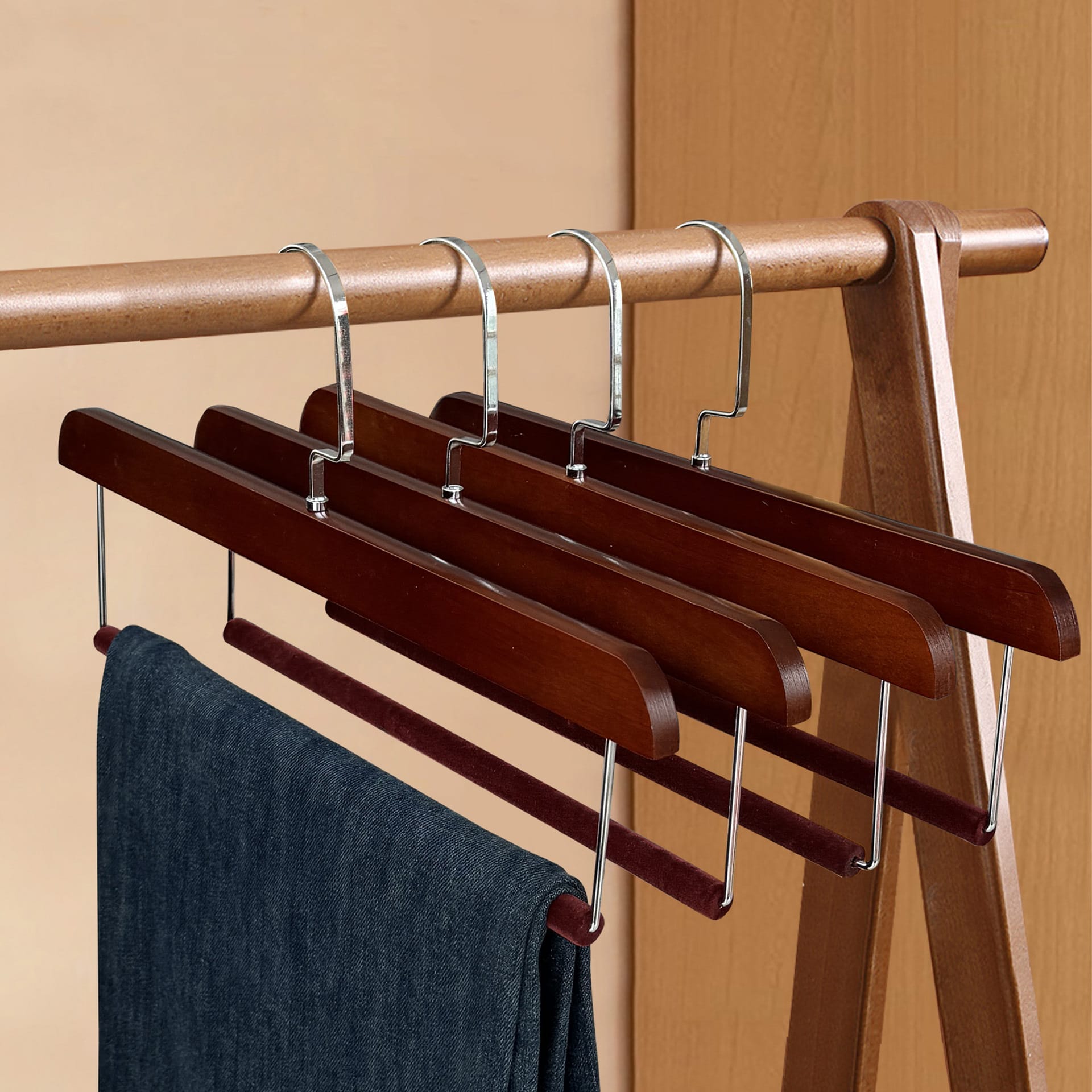 Dark brown wooden pant hangers with velvet bars, perfect for closet organization. Set of four.