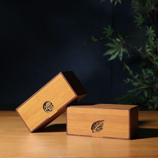 Bamboo Wooden Tea Box: Two elegant, wholesale custom-made tea boxes crafted from high-quality bamboo wood. One features a leaf design, the other a Chinese character.