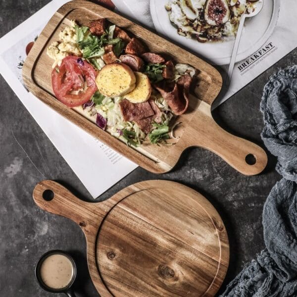 This wooden tray with handles serves as an ideal solution for serving steak, breakfast, pizza, or Western dishes in both home and commercial settings. Its rectangular shape and ergonomic handles provide convenience and style, suitable for restaurants, cafes, and household dining. Quality and Materials: Premium Wood Craftsmanship Made from high-quality, durable wood, this tray ensures long-lasting use and resistance to wear. The natural wood grain enhances the aesthetic appeal while the smooth finish protects against moisture and stains, making it easy to clean and maintain. Customization Options: Tailored to Your Needs Customization includes adjustable dimensions, color finishes, and personalized engraving such as logos or patterns via laser engraving. These options enable branding opportunities and meet diverse market demands with unique designs. Ordering and Shipping: Efficient and Flexible Minimum order quantity (MOQ) is flexible to accommodate small or bulk purchases. Products are shipped via reliable logistics partners ensuring timely delivery worldwide. Packaging is designed to protect the tray during transit. Product Benefits & Target Audience: Ideal for Foodservice & Retail This wooden tray with handles is perfect for wholesalers, retailers, and brand owners targeting foodservice businesses, including restaurants, hotels, and cafes. It enhances presentation quality and customer experience, adding commercial value. Service Advantages: Supportive and Responsive Offers low MOQ, OEM/ODM manufacturing support, fast shipping, and responsive after-sales service to meet client requirements efficiently. This ensures smooth cooperation from order placement to post-delivery support. , one rectangular and one round, with handles. Eco-friendly pizza serving platters, wholesale available.
