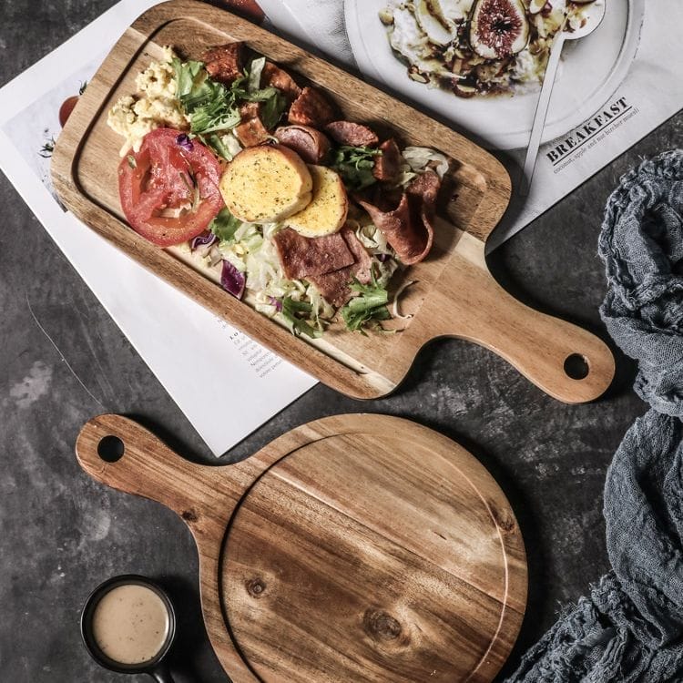 This wooden tray with handles serves as an ideal solution for serving steak, breakfast, pizza, or Western dishes in both home and commercial settings. Its rectangular shape and ergonomic handles provide convenience and style, suitable for restaurants, cafes, and household dining. Quality and Materials: Premium Wood Craftsmanship Made from high-quality, durable wood, this tray ensures long-lasting use and resistance to wear. The natural wood grain enhances the aesthetic appeal while the smooth finish protects against moisture and stains, making it easy to clean and maintain. Customization Options: Tailored to Your Needs Customization includes adjustable dimensions, color finishes, and personalized engraving such as logos or patterns via laser engraving. These options enable branding opportunities and meet diverse market demands with unique designs. Ordering and Shipping: Efficient and Flexible Minimum order quantity (MOQ) is flexible to accommodate small or bulk purchases. Products are shipped via reliable logistics partners ensuring timely delivery worldwide. Packaging is designed to protect the tray during transit. Product Benefits & Target Audience: Ideal for Foodservice & Retail This wooden tray with handles is perfect for wholesalers, retailers, and brand owners targeting foodservice businesses, including restaurants, hotels, and cafes. It enhances presentation quality and customer experience, adding commercial value. Service Advantages: Supportive and Responsive Offers low MOQ, OEM/ODM manufacturing support, fast shipping, and responsive after-sales service to meet client requirements efficiently. This ensures smooth cooperation from order placement to post-delivery support. , one rectangular and one round, with handles. Eco-friendly pizza serving platters, wholesale available.