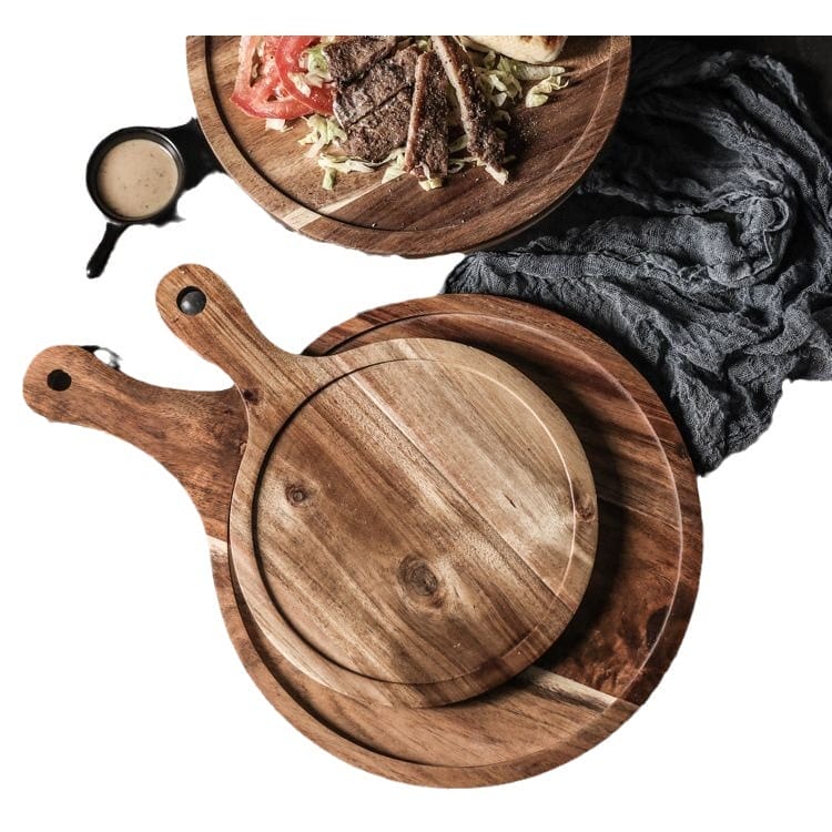 Two acacia wood pizza serving platters, one with handles, ideal for restaurants or wholesale eco-friendly food service.