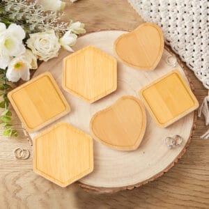 Six wooden ring dishes in heart, square, and hexagon shapes on a wood slice.
