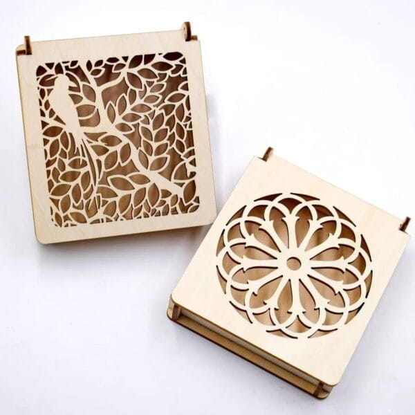 Custom Carved Wooden Boxes: Two laser-cut wooden boxes, one with a bird & leaf design, the other with a floral design. Wholesale available.