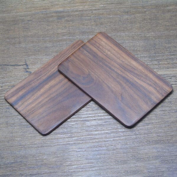 Custom Laser Cut Wooden Business Card Holders: Wholesale pack of two elegant dark brown wooden coasters. Perfect for business cards or display.