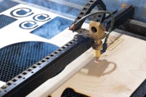 Laser cutter engraving designs onto plywood.