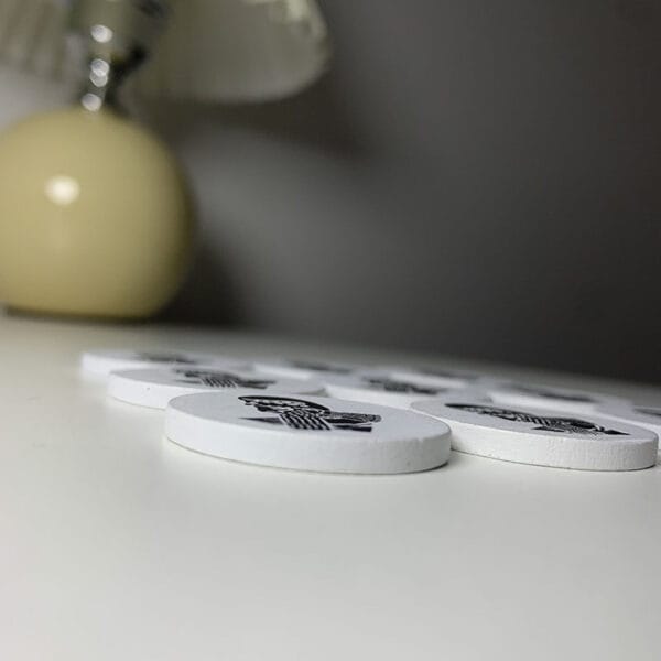 Custom Personalized Wooden Coins: Wholesale lot of round white wooden coins with unique black & white designs. Perfect for games or crafts.