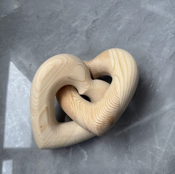 Interlocking Wooden Heart Sculpture: Handcrafted wooden hearts, perfect for home decor or gifts.