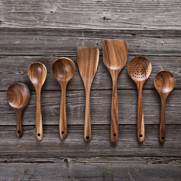 Set of custom teak wood cooking spoons, including spoons, spatulas, and slotted spoon. Perfect for wholesale.