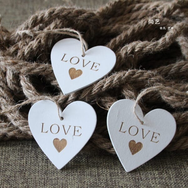 Custom Wooden Hearts: Three white, heart-shaped wedding decorations with "LOVE" engraved, perfect craft supplies for wholesale.