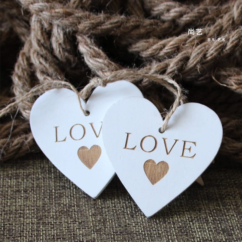 Custom Wooden Hearts: Two white wooden hearts with "LOVE" engraved, perfect for wedding crafts and wholesale orders.
