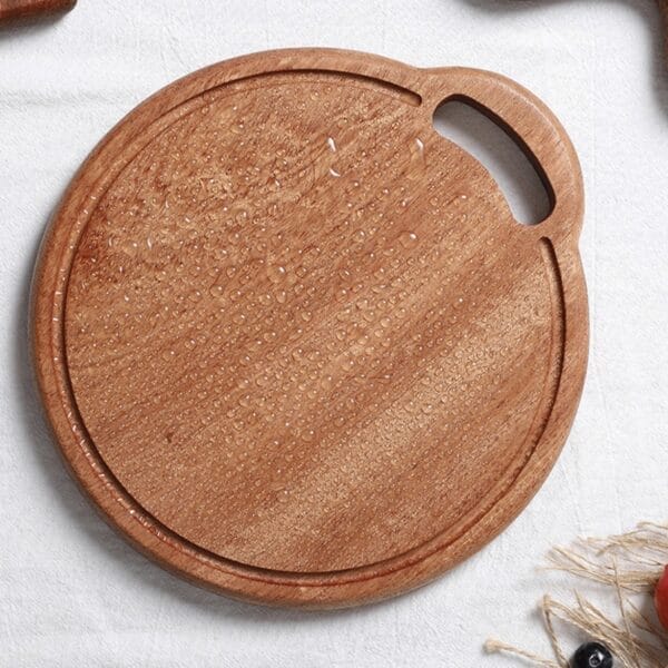 Round acacia wood cutting board with handle; perfect for serving or chopping.