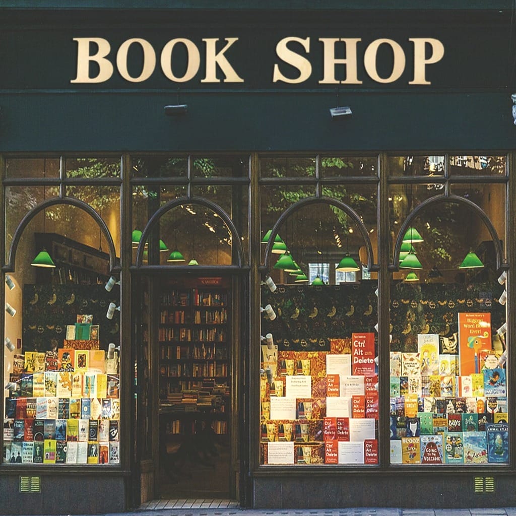 Book Shop exterior with large windows displaying books. Green awning and inviting atmosphere for book lovers.