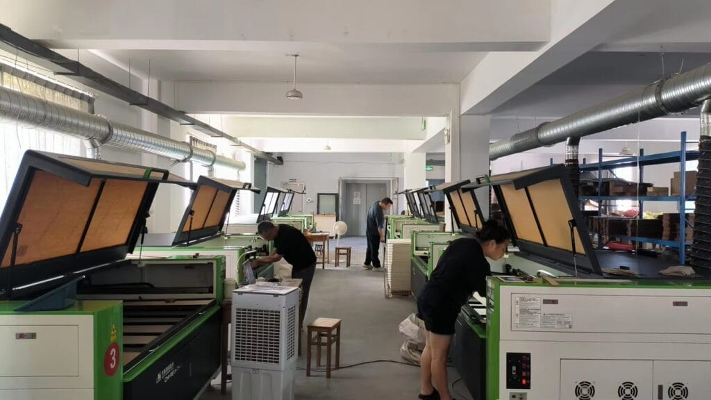 Laser cutting workshop with workers using machines. Manufacturing process.