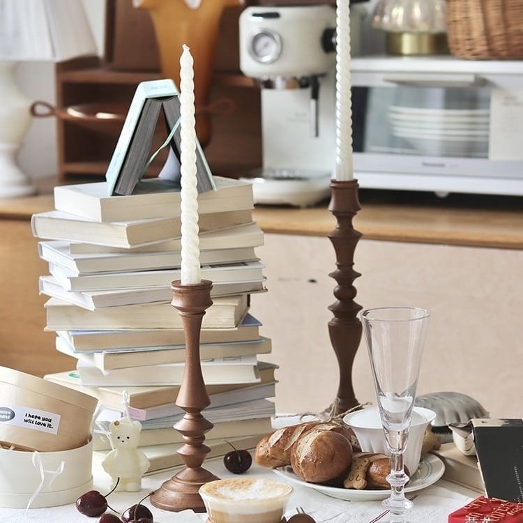 Rustic Oak Candlesticks: Pair of wooden candlesticks with candles, styled with books, bread, and cherries.