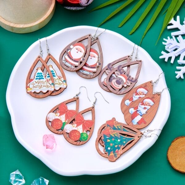 Christmas earrings: Teardrop wood earrings with Santa, reindeer, trees, and ornaments on a white plate