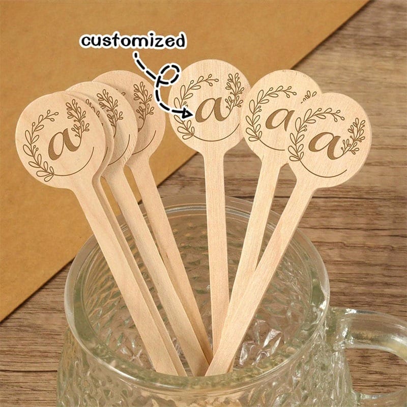 Custom wooden stir sticks with "a" initial and leaf design, perfect for personalized wedding favors and party supplies.