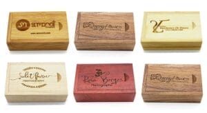 Wooden USB boxes with engraved photography logos. Customizable photo storage solutions.