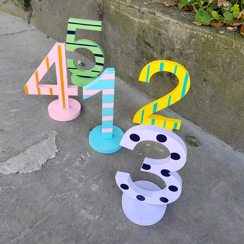 Colorful wooden numbers 1, 2, 3, 4, 5. Decorative, standing numerals for kids or home decor.