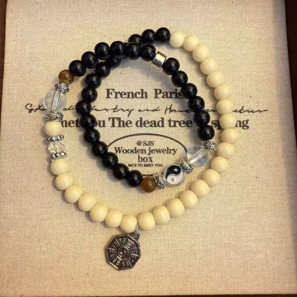 Black and white beaded bracelets with Yin Yang and other charms on a decorative box