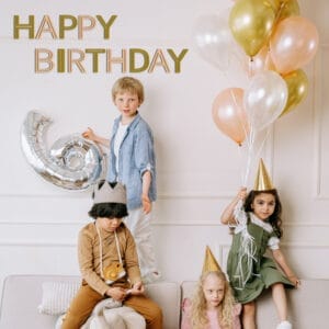 Kids celebrating a 6th birthday with balloons and party hats. Happy Birthday text overlay.