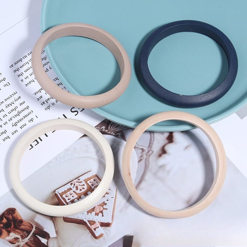 Wholesale Wooden Bangle Bracelets: Polished natural wood bangles in beige, dark blue, white, and light brown.