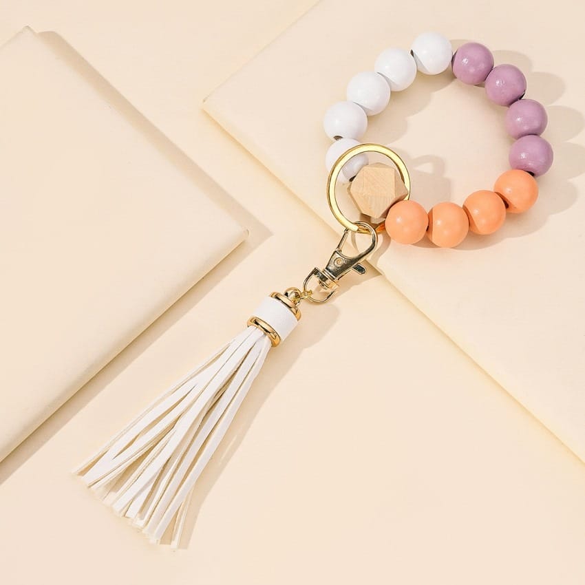 AUTO-DRAFT bracelet keychain with white, purple, and orange wooden beads and white tassel