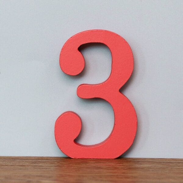 Red wooden number three. Decorative craft number.
