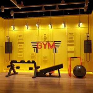 Home gym setup with weights, bench, and exercise ball. "GYM" sign in neon.