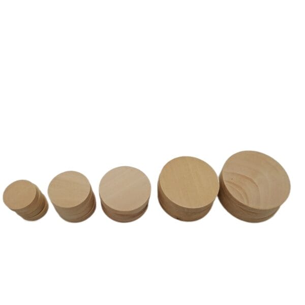 Stacks of round wood discs, various sizes. Craft supplies.