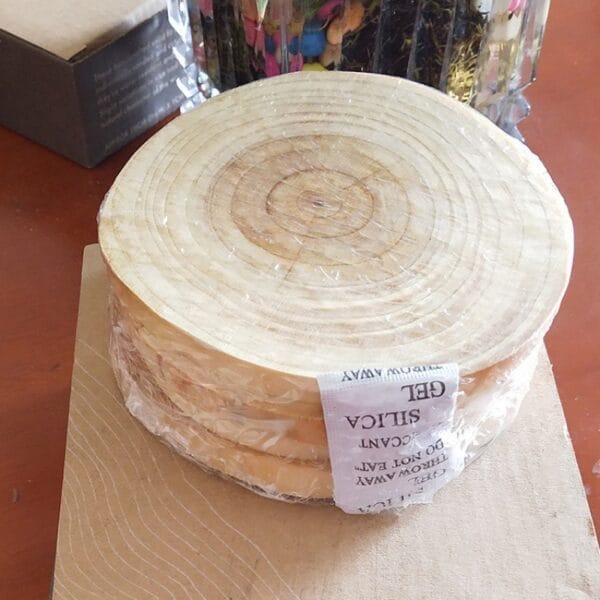 Stack of round wooden discs, wrapped in plastic with silica gel, for crafting or decoration