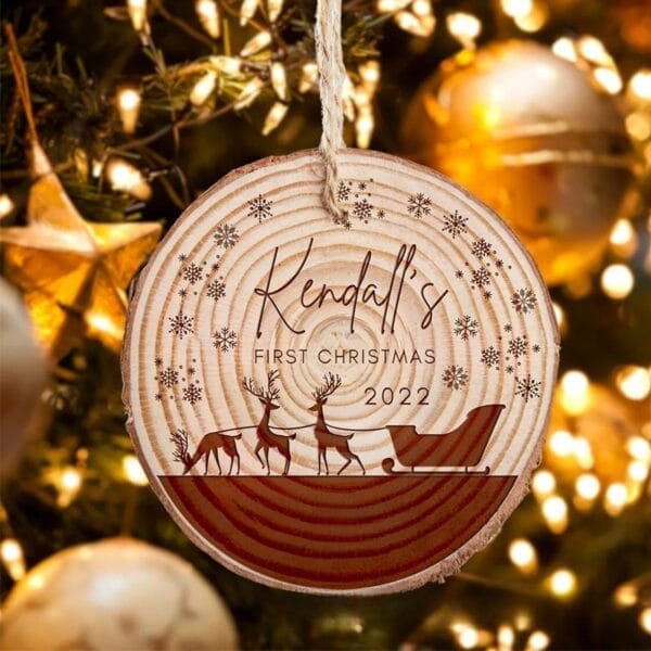 Rustic Wood Slice Ornament: "Kendall's First Christmas 2022" with reindeer sleigh design.