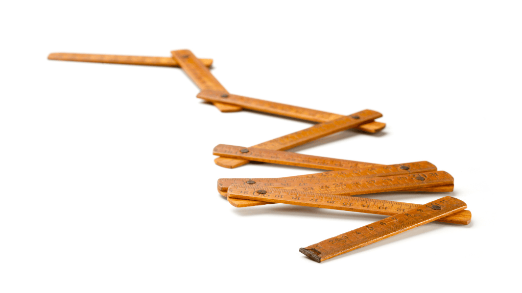 The Value of Wooden Folding Rules: Vintage wooden folding rule, a timeless precision tool, shown partially extended on a white background.