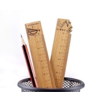 Wooden rulers and a pencil in a black wire mesh cup. Measurement tools.