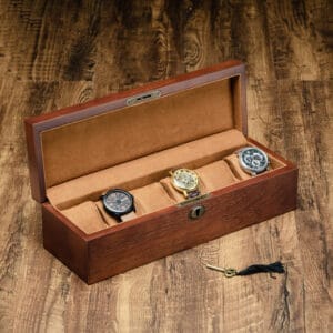 Wooden watch box with four wrist watches and a key.