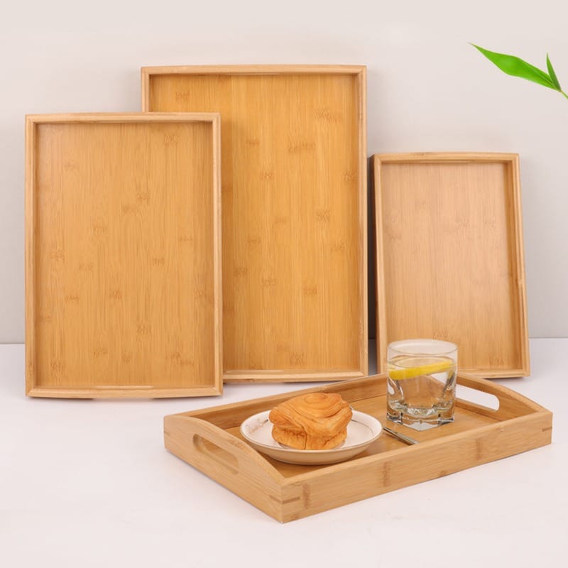 Large Personalised Wooden Butler Tray: Bamboo serving trays, including one with pastry and water glass.